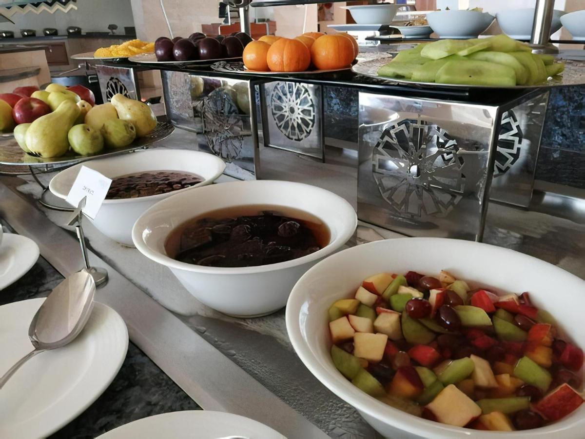 Tolip Resort El Galala Majestic Ain Soukhna Exteriér fotografie The photo shows a buffet-style arrangement of various fruits and fruit dishes. In the foreground, there are several bowls containing different types of fruit. One bowl has a fruit salad made with diced apples, green apples, and possibly other fruits.